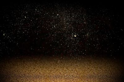 Gold confetti on dark background.