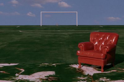 Red Armchair on Field Photography Poster.