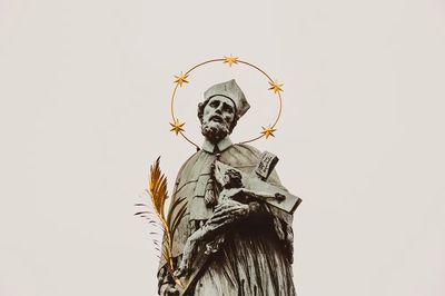 Stone statue saint crucifix gold.