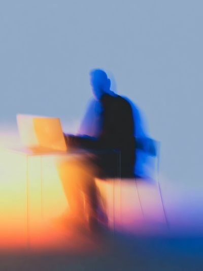 Blurred Figure at Laptop Photography Poster.