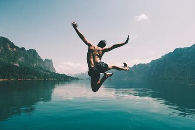 Man jumping joy lake. poster