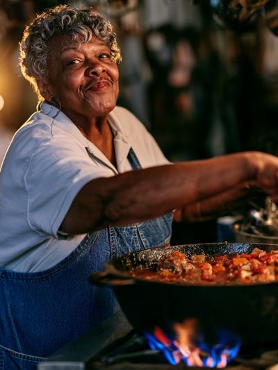 Smiling Cook at the Stove Photography Poster.
