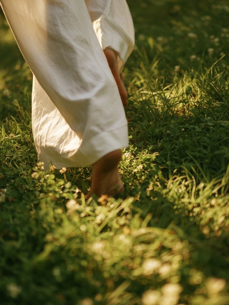 Barefoot Walk in Sunlit Grass Photography Poster. poster detail