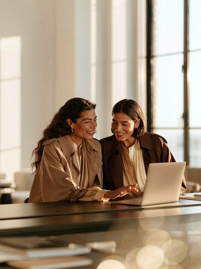 Sunlit Women at Laptop Photography Poster.