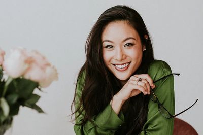 Beautiful cheerful Asian woman sitting.