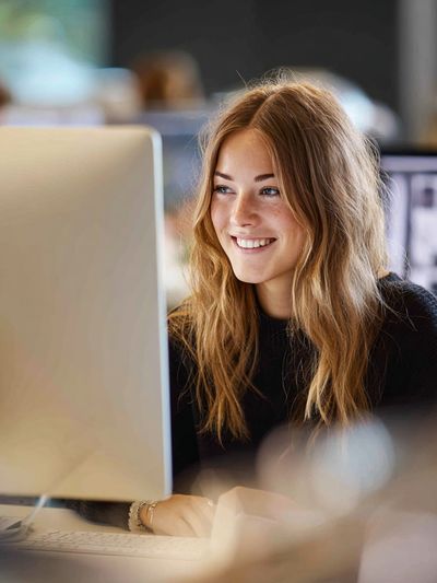 Smiling Woman at Desk Photography Poster.