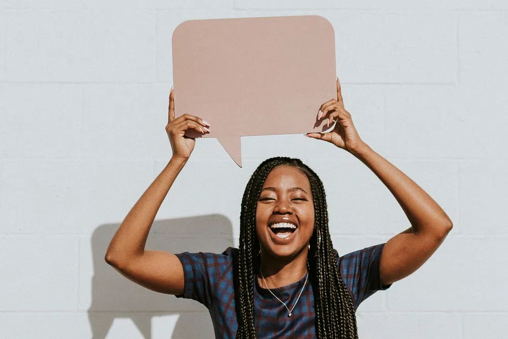 Cheerful black woman showing blank. poster detail