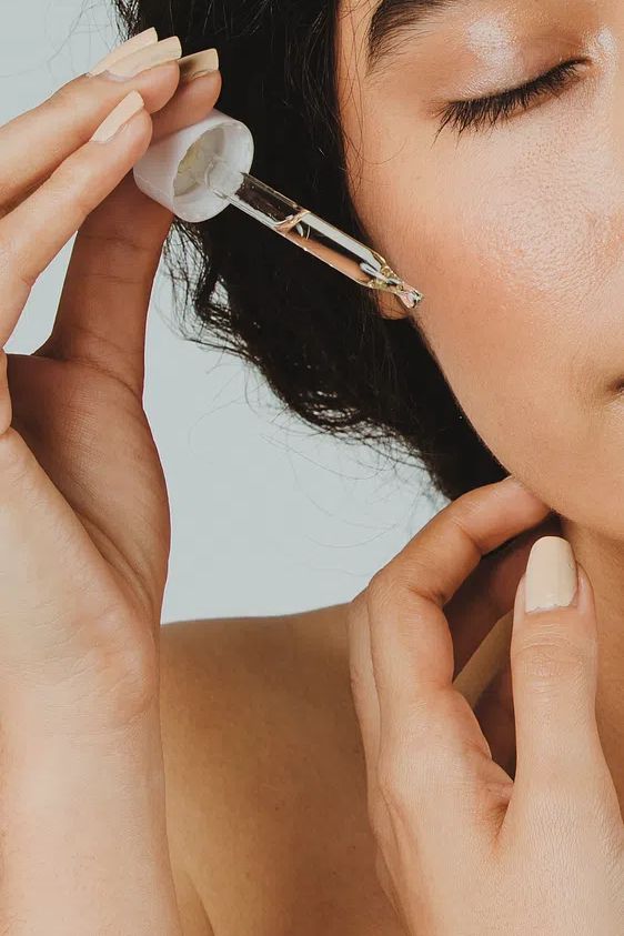 Young woman applying serum her. poster detail