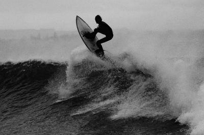 black white photo surfer catching.