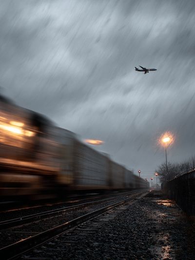 Train and Airplane in Rainy Landscape Poster. poster
