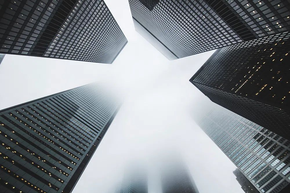 low-angle shot skyscrapers foggy day. poster detail