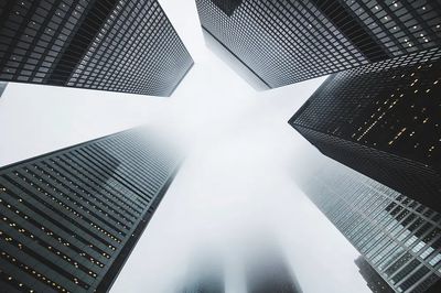 low-angle shot skyscrapers foggy day.